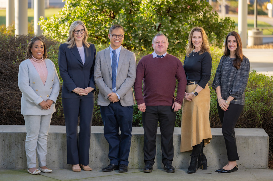 A group of nursing faculty standing next to each other posing for a photo outside