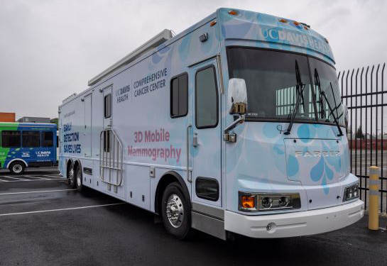 Front of large white bus with signage on sides.