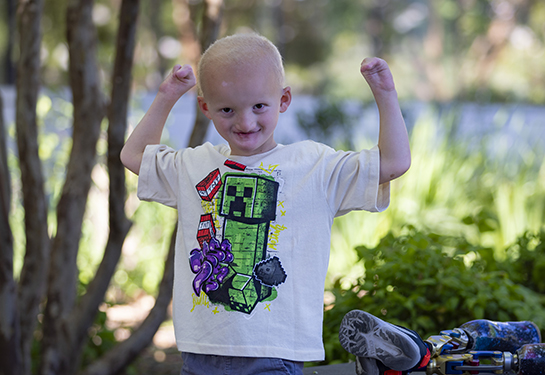 Child with arms up in a hero pose