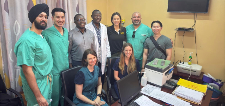 Group of doctors standing together behind a desk.
