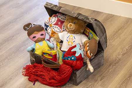 Trunk filled with toys, a blanket and crayons