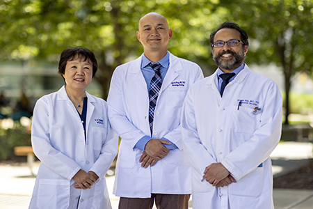 Three clinical trial leads, one female and two male faculty members, standing together posed for a group photo.