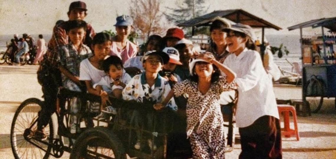 historical photo of Vietnamese family riding a bike and running in the street
