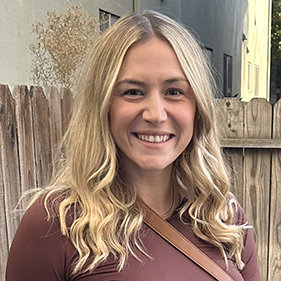 Headshot of a blonde woman in a brown shirt.