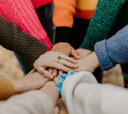 Image of hands placed one on top of the other to demonstrate solidarity and support