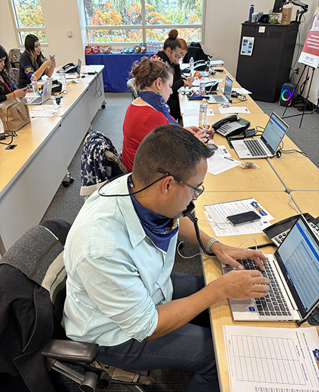 People sit at table answering phones.