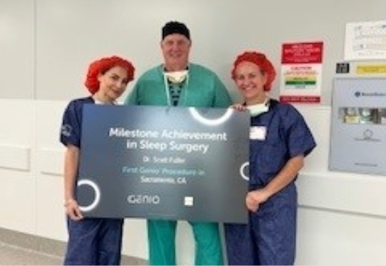 Three people in surgical attire stand in a hallway holding a sign that reads “Milestone Achievement in Sleep Surgery.”