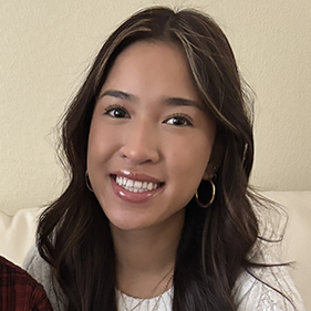 Headshot of young Asian woman with black hair wearing a white sweater.