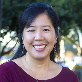 Christine Wu Nordahl, MIND Institute researcher, poses for a photo outside while wearing a purple shirt. 
