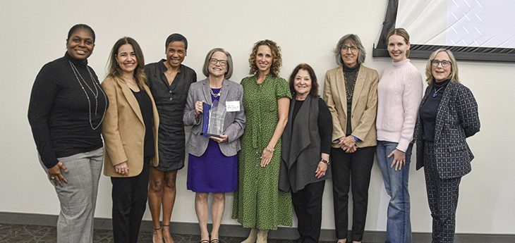 Eight members of the Women & Philanthropy Advisory Council pose for a photo with Amy Brooks-Kayal, the winner of the 2025 Women & Philanthropy Impact Award.