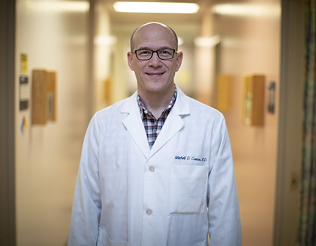 Portrait of Mitchell Creinin wearing white coat in hospital hallway
