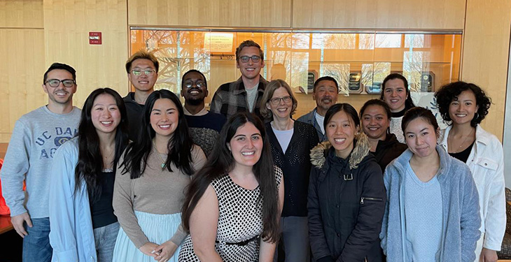 Janine LaSalle surrounded by 13 members of her lab.