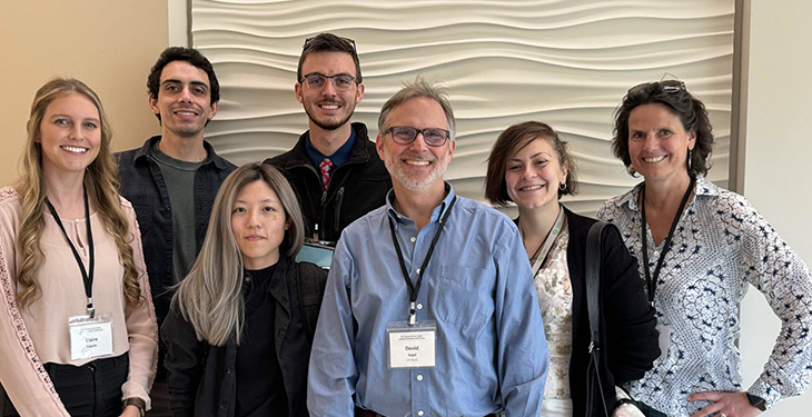 Professor David Segal and six of his lab members smiling to the camera.