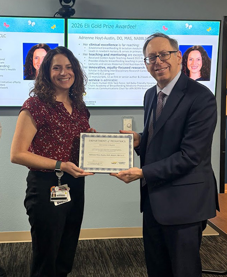 Man hands woman award in meeting room. 
