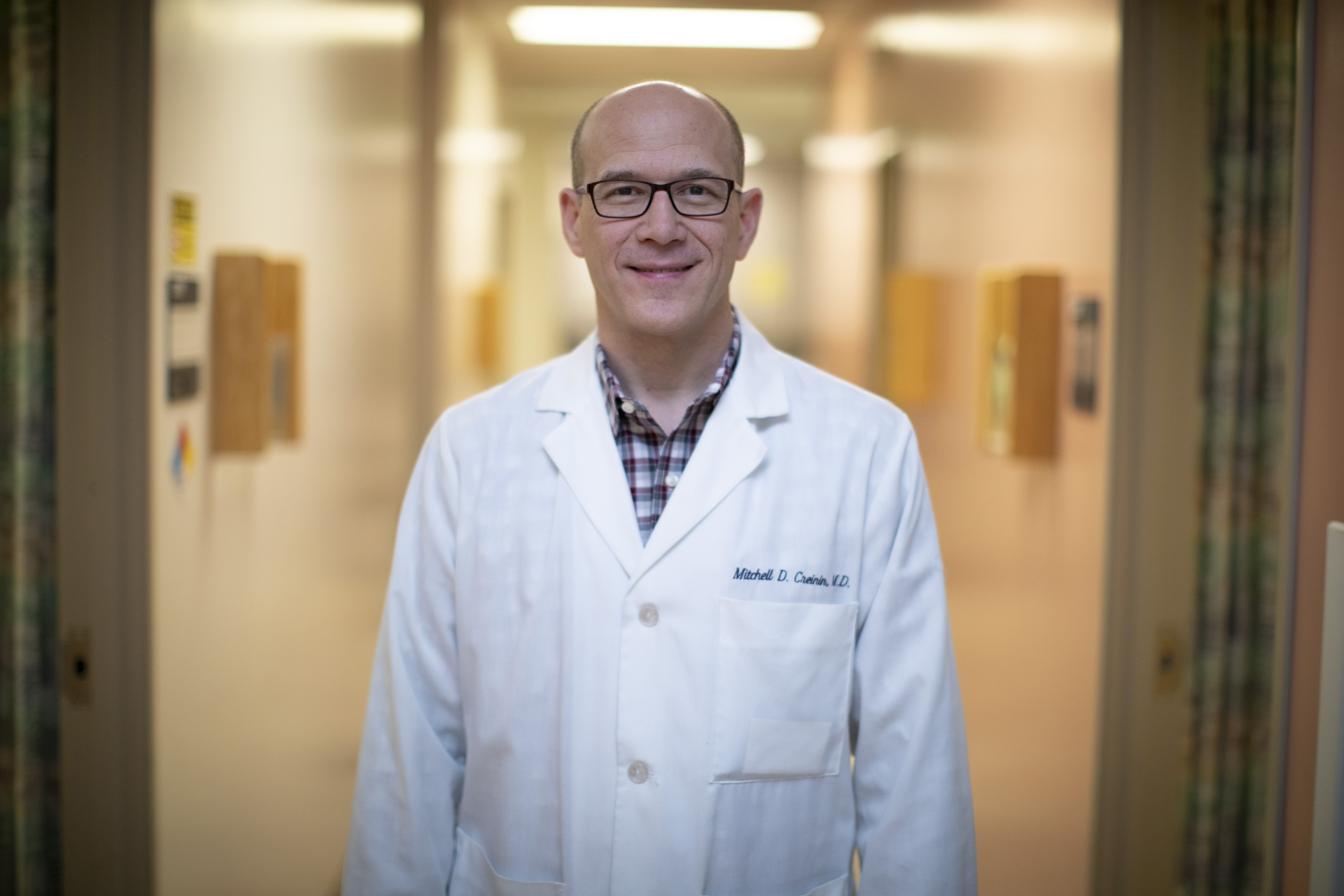 Portrait of Mitchell Creinin wearing white coat in hospital hallway