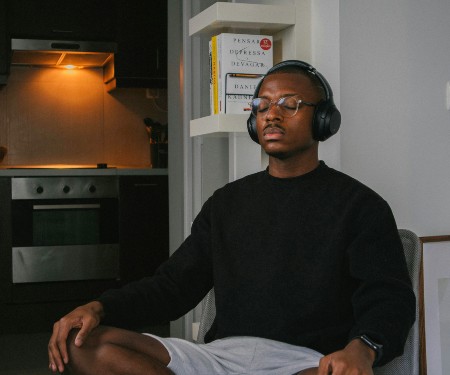 A man looking relaxed as he sits in a chair wearing headphones