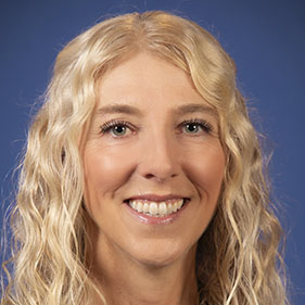 Rebecca Schmidt, with long curly blonde hair, smiles for the camera. 