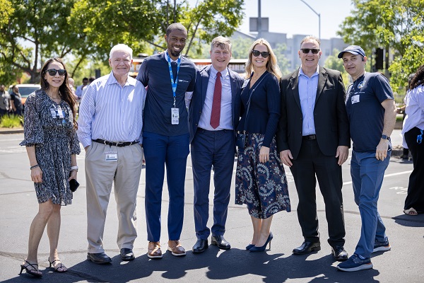A group of seven attendees stands together outdoors posing for a group photo.