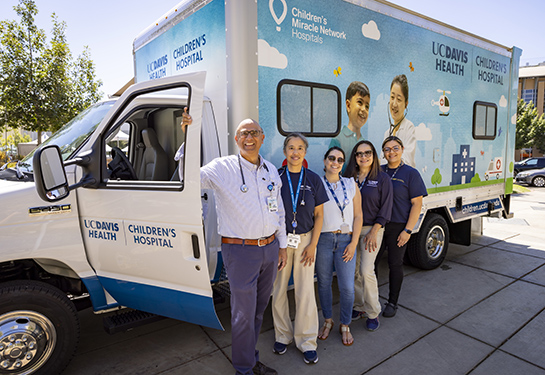 5 people stand in front of the van. 