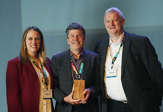 Professor Simon Cherry is holding the ESMI Award, with Dr. Irene Marco Ruiz on his right and Professor Bernd Pichler on his left.