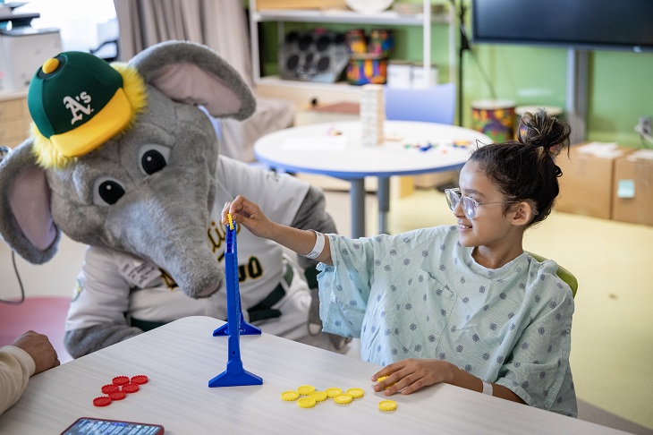 A's mascot Stomper watches a game of Connect 4