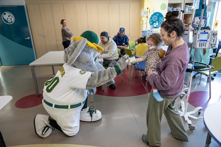 A's mascot Stomper fist bumps a toddler.