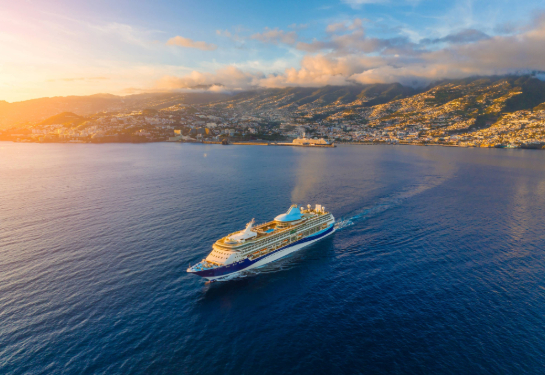 Ship sailing on calm ocean waters with land in the background.