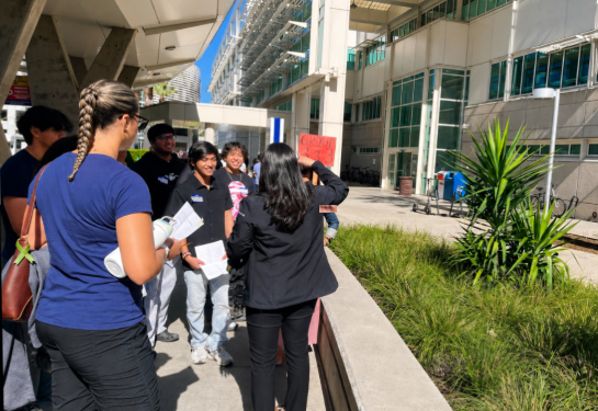 group of students gathered outside the medical center looking at field trip guide