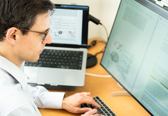 Sergey Stavisky sits at a desk, working at a computer. 