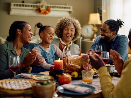 A family gathered around a dinner table and laughing