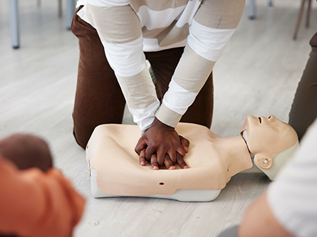 Person performs CPR with a mannequin