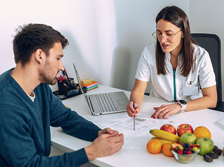 female dietitian explaining health information to male patient in a clinic