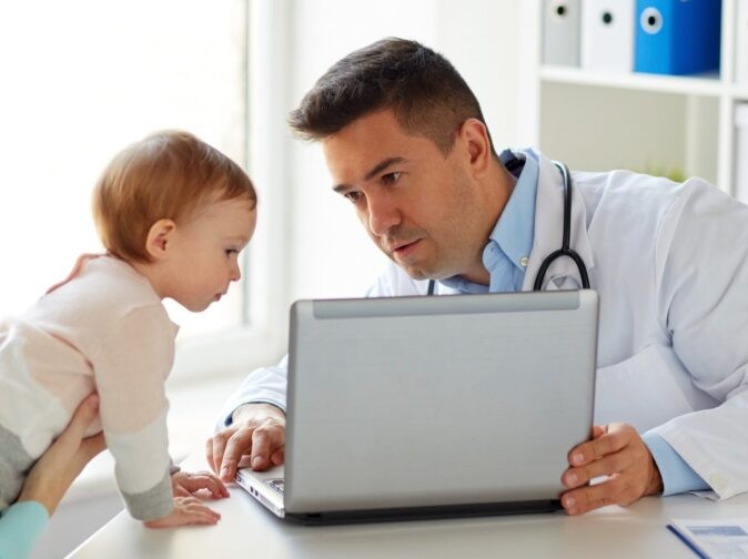 doctor at a computer with little girl