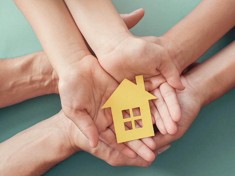 hands holding a paper home cut out