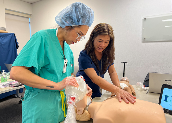 A nursing student and instructor demonstrating CPR.