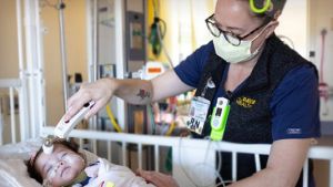 PICU nurse checking infant
