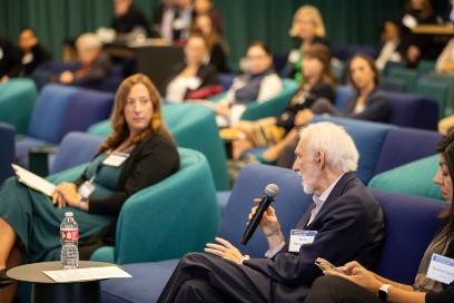 A speaker sitting in the crowd at a conference