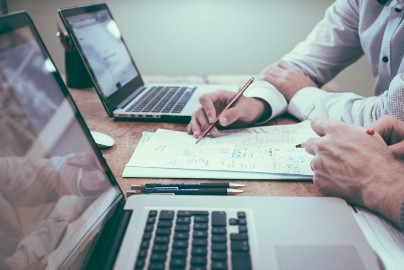 Two people reviewing data on paper while sitting at a desk