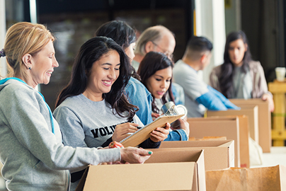 A group of volunteers working together packing bags.