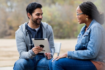 Man showing a tablet screen to a woman
