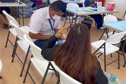 Latino male giving a survey to a woman 