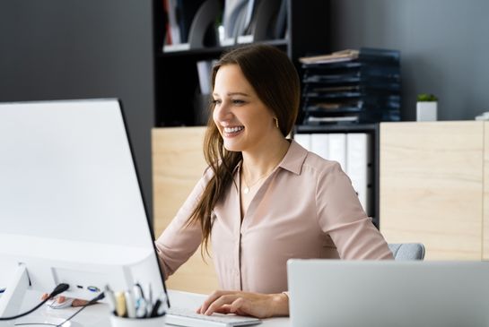 woman sitting at a desk looking at a computer