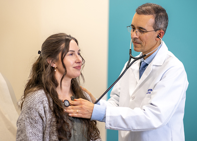 Primary care doctor Victor Baquero using a stethoscope to listen to a patient’s heart