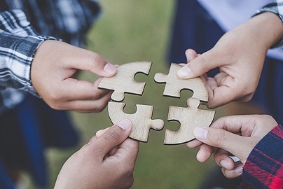 four puzzle pieces once separated in the process of being placed together