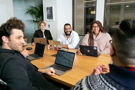 diverse group of people sitting at a table talking