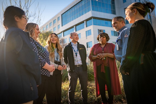 diverse group of people standing and talking outside building