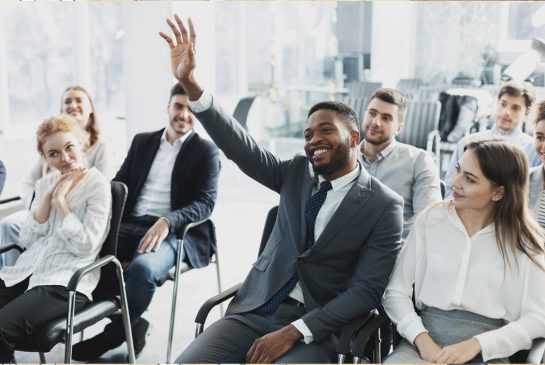 classroom of learners with one raising his hand