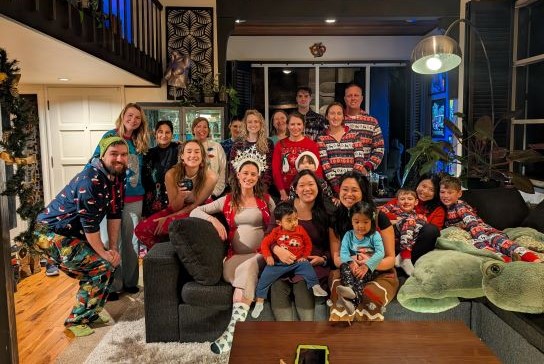 Group photo with faculty and families dressed in holiday pajamas at a WIMHS departmental holiday event