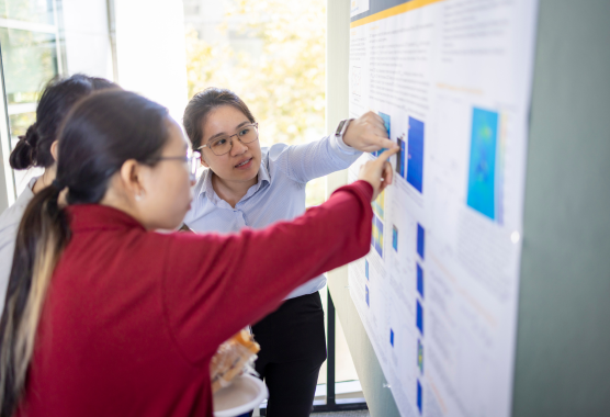 academic researchers reviewing a poster