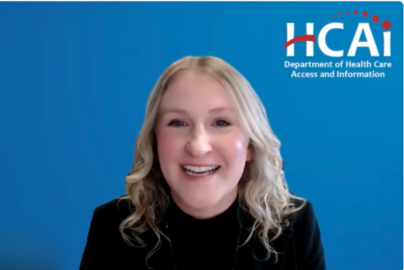 A webinar panelist with blonde hair smiles in front of a virtual background with an HCAI logo.